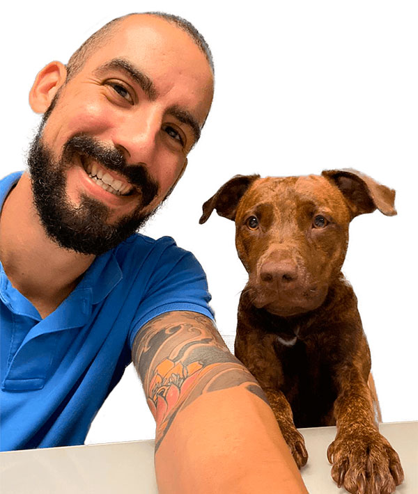 Veterinário Thiago Lico com cão no Centro Veterinário Vet Taboão